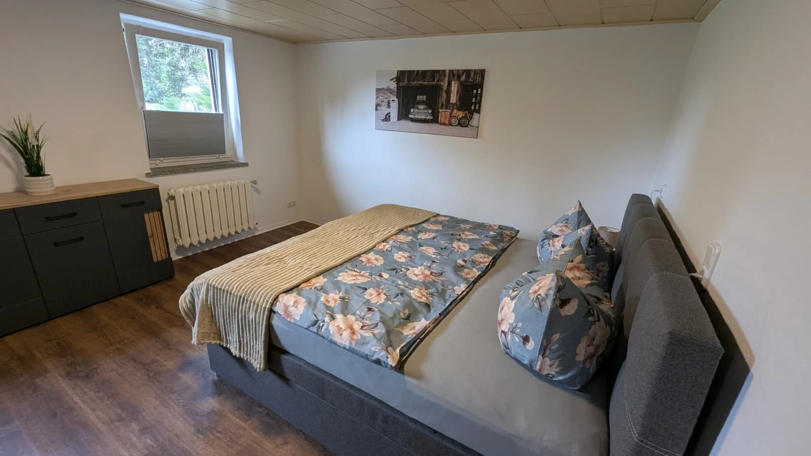 Pensionszimmer im Obergeschoss mit Bett und Kommode